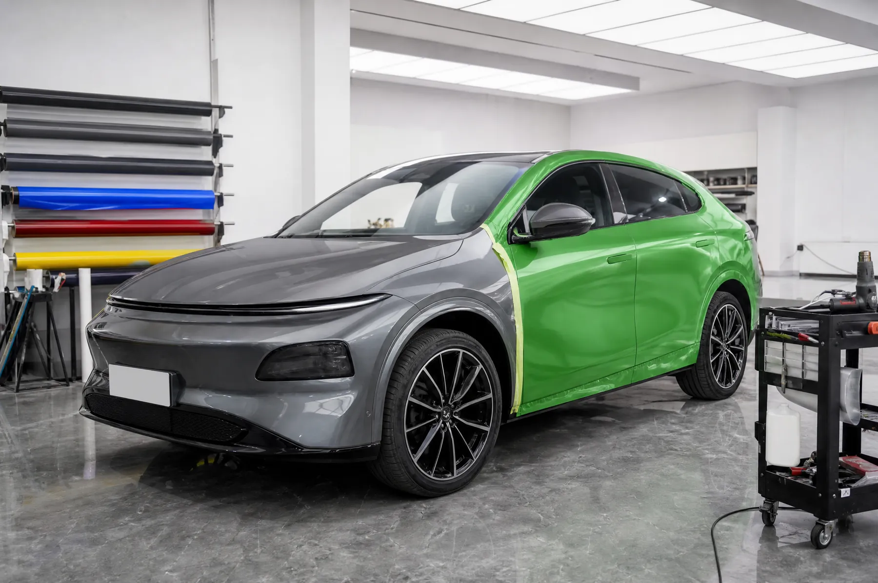 A car half-way through being wrapped in green film